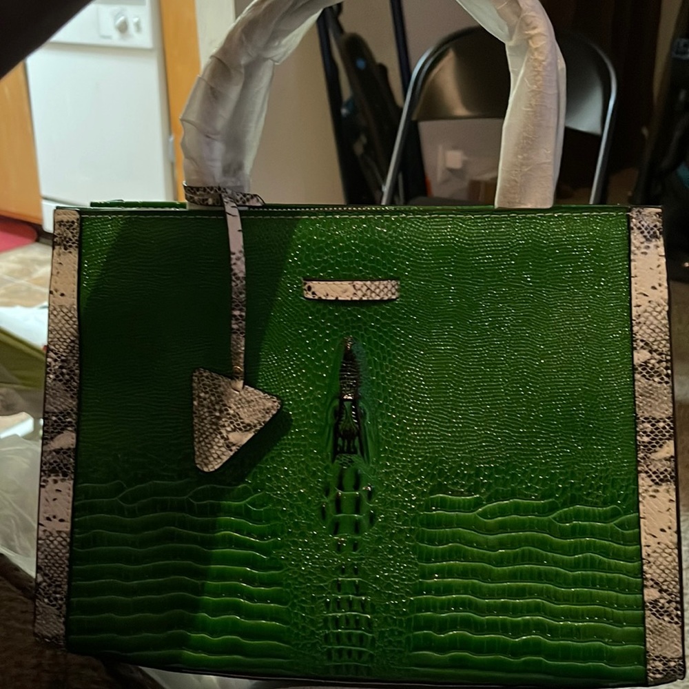 Green with alligator print on side, the shape of an alligator on front of bag
